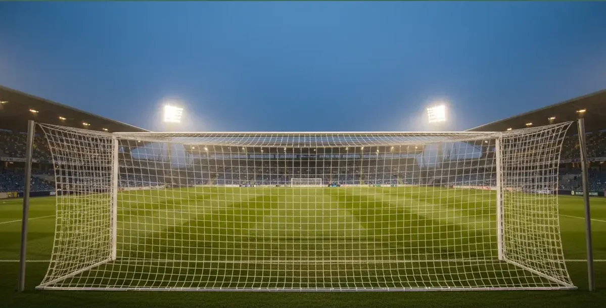 Voetbalveld tijdens een avondwedstrijd met verlichte stadionlampen — wedden op voetbal gids